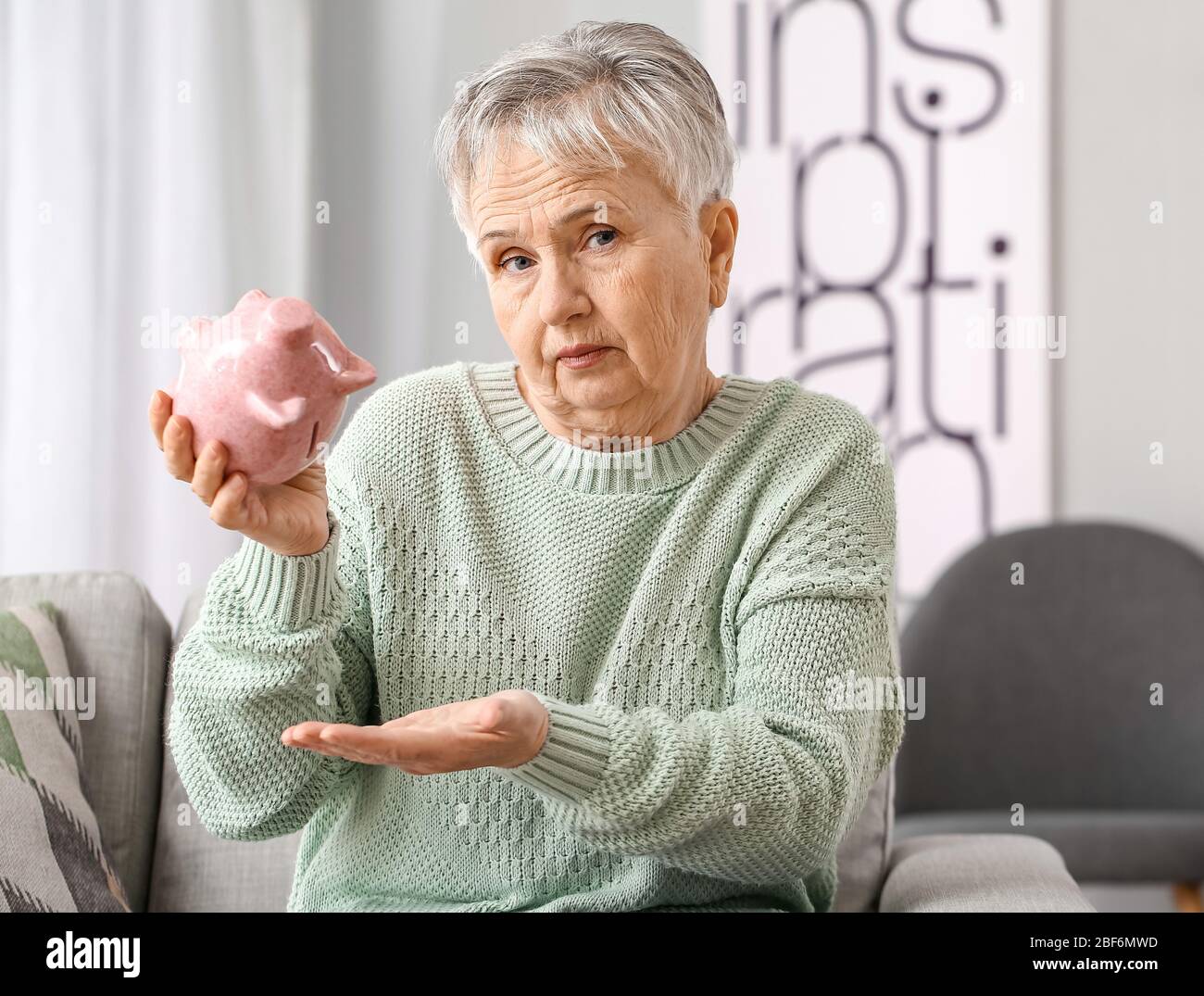 Sad senior woman with empty piggy bank at home Stock Photo - Alamy