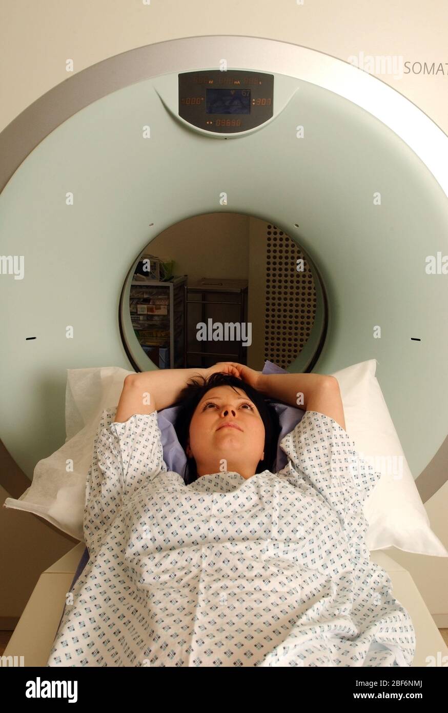 A Siemens CT scanner A patient lies on the examination table of a computed tomography scanner, better known as CAT or CT scanner, which produces three Stock Photo