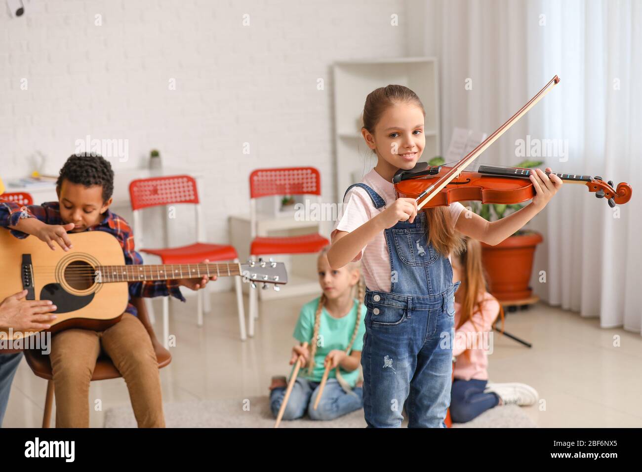 Cute little girl playing violin at music school Stock Photo - Alamy