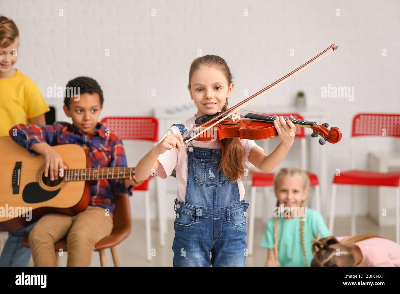 Cute little girl playing violin at music school Stock Photo - Alamy