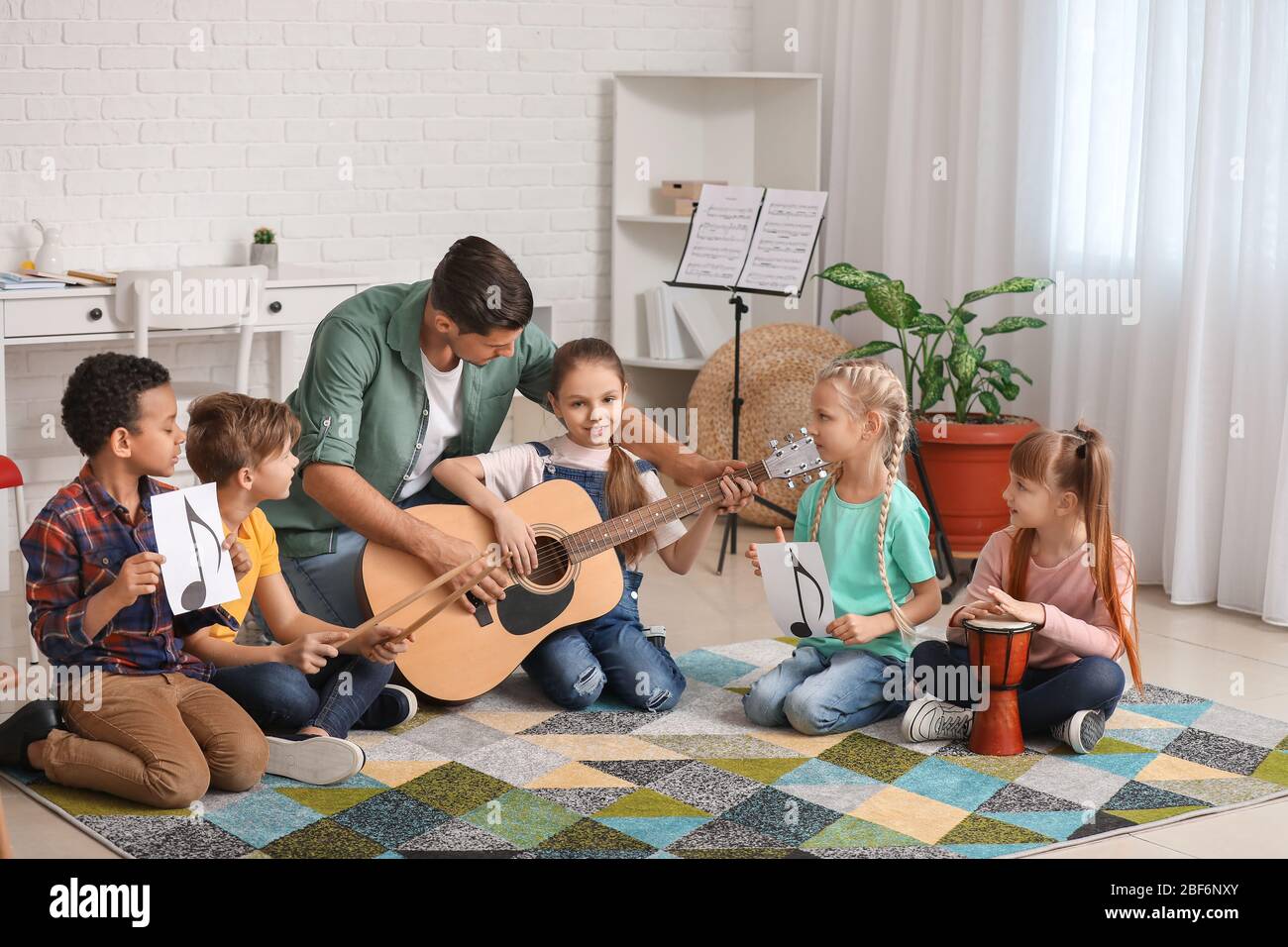 Teacher giving music lessons at school Stock Photo Alamy