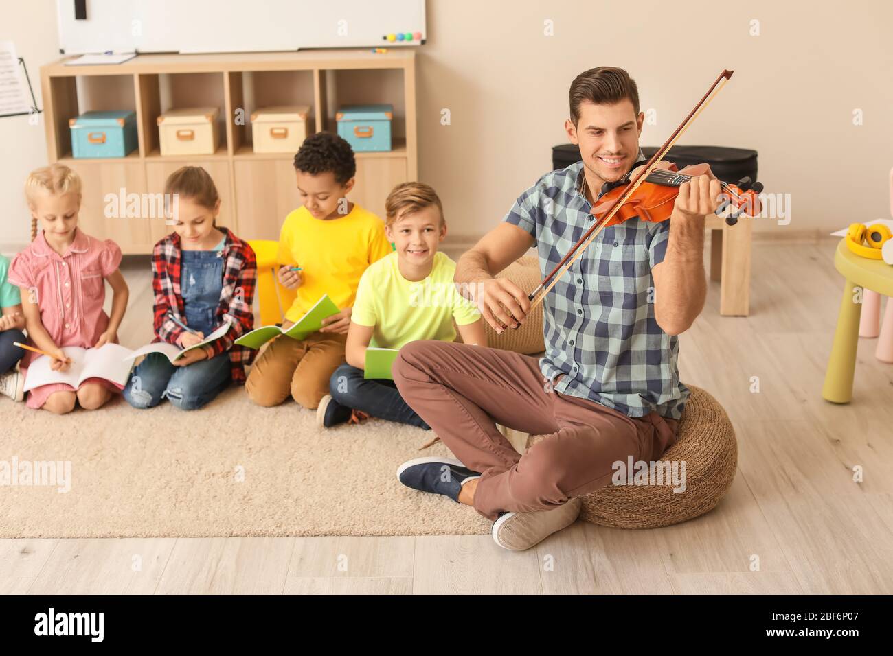 Teacher giving music lessons at school Stock Photo Alamy