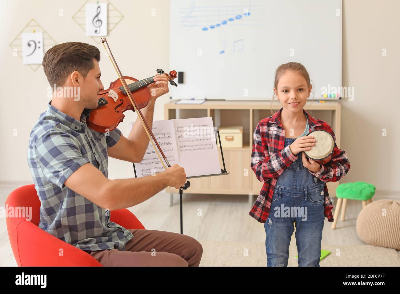 Teacher giving music lessons at school Stock Photo Alamy
