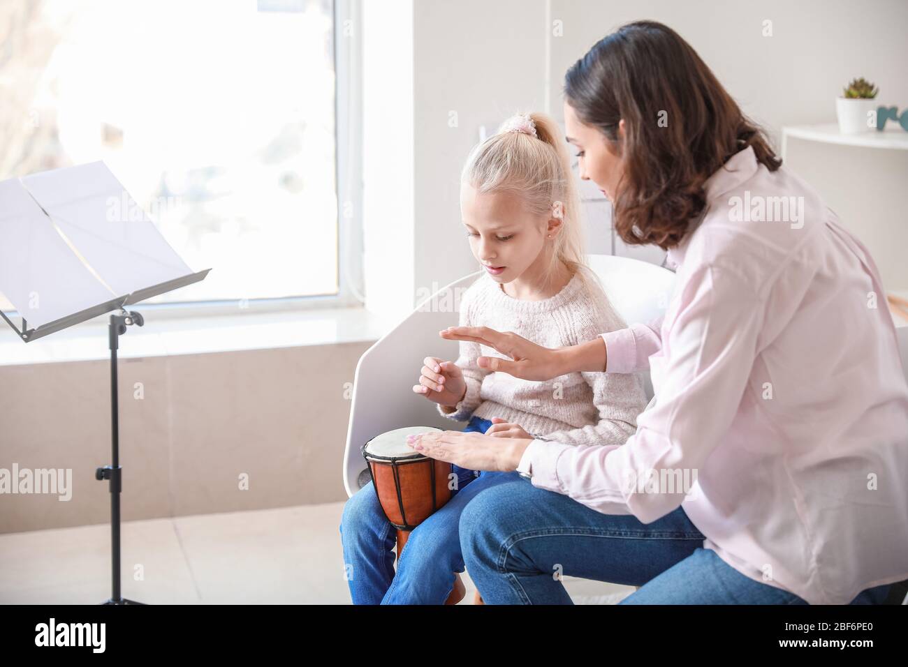 Private music teacher giving lessons to little girl at home Stock Photo ...