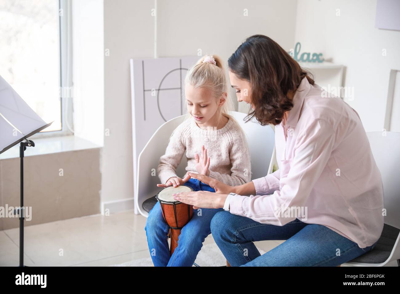 Private music teacher giving lessons to little girl at home Stock Photo ...
