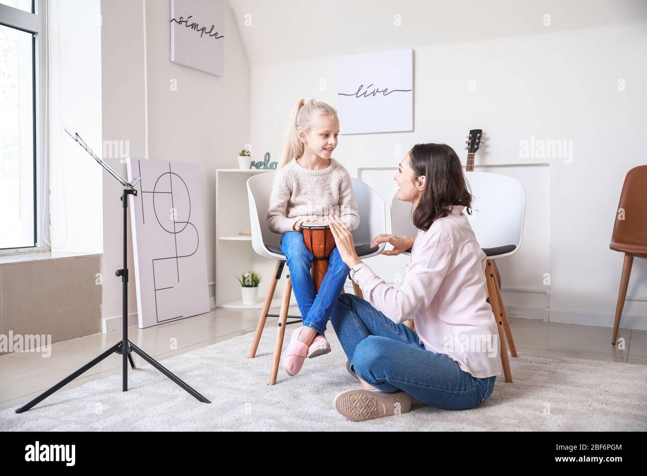 Private music teacher giving lessons to little girl at home Stock Photo ...