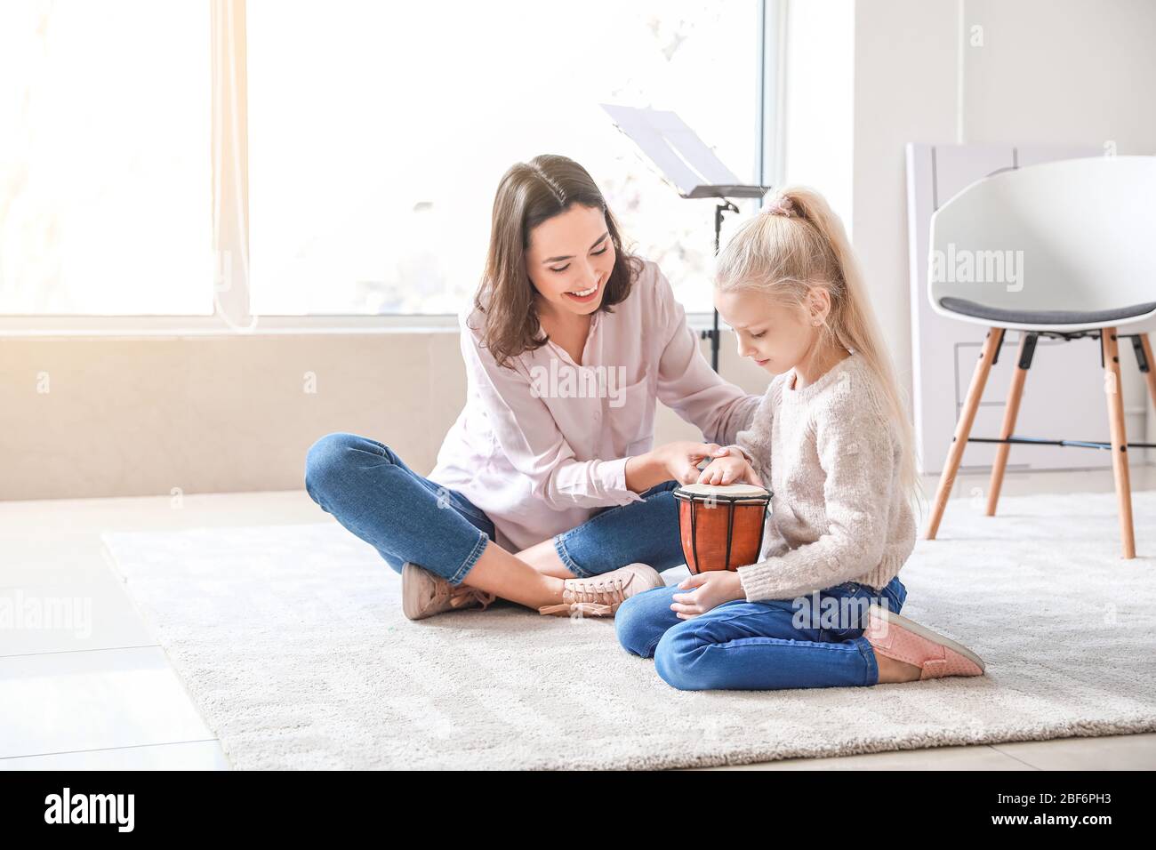Private music teacher giving lessons to little girl at home Stock Photo ...