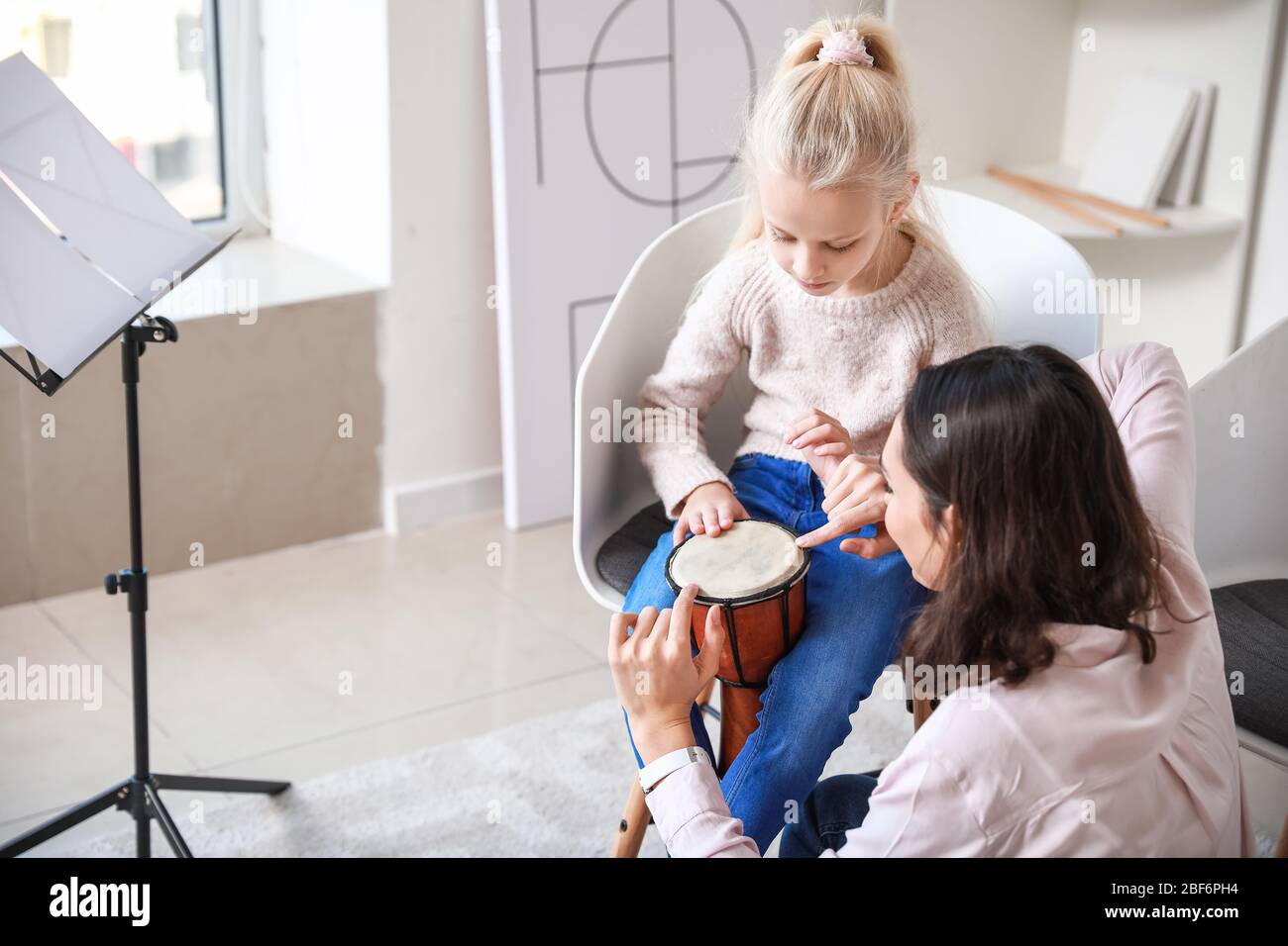 Private music teacher giving lessons to little girl at home Stock Photo ...
