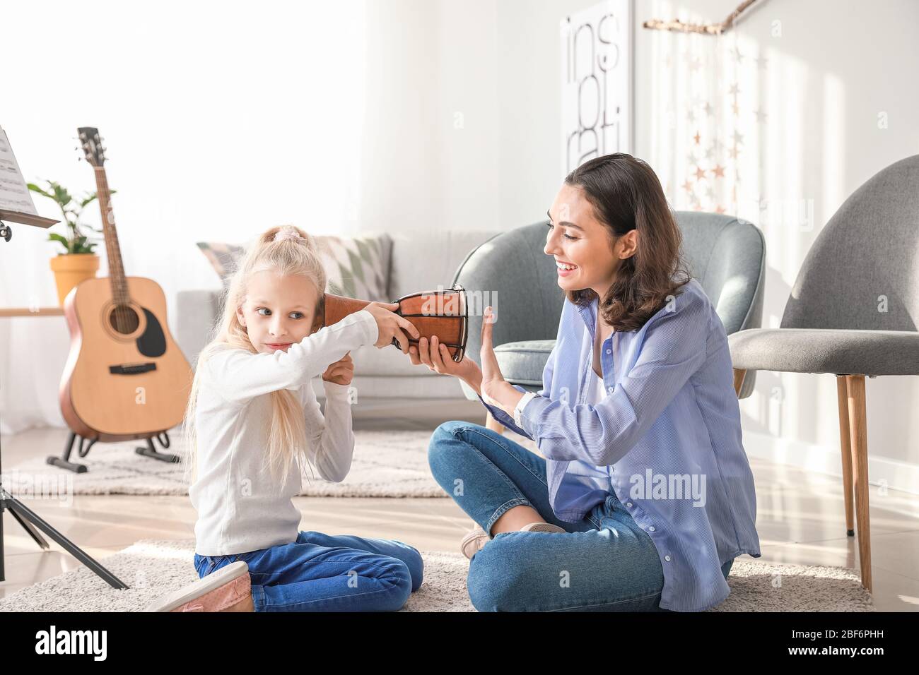 Private music teacher giving lessons to little girl at home Stock Photo ...