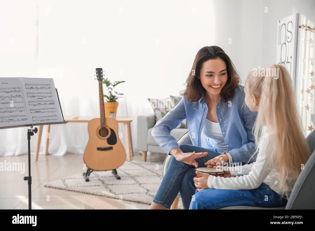 Private music teacher giving lessons to little girl at home Stock Photo ...