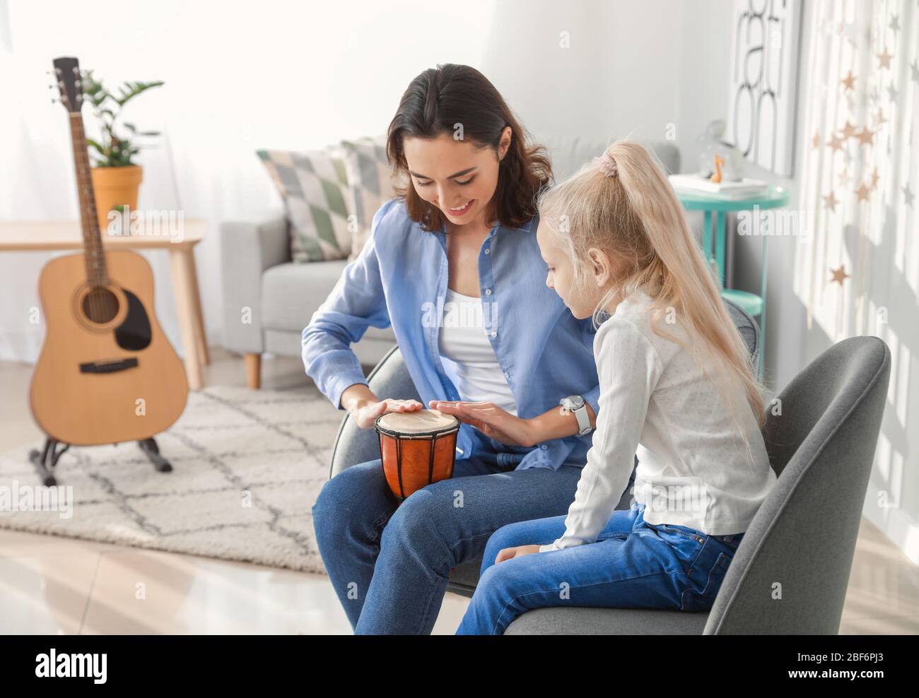 Private music teacher giving lessons to little girl at home Stock Photo ...