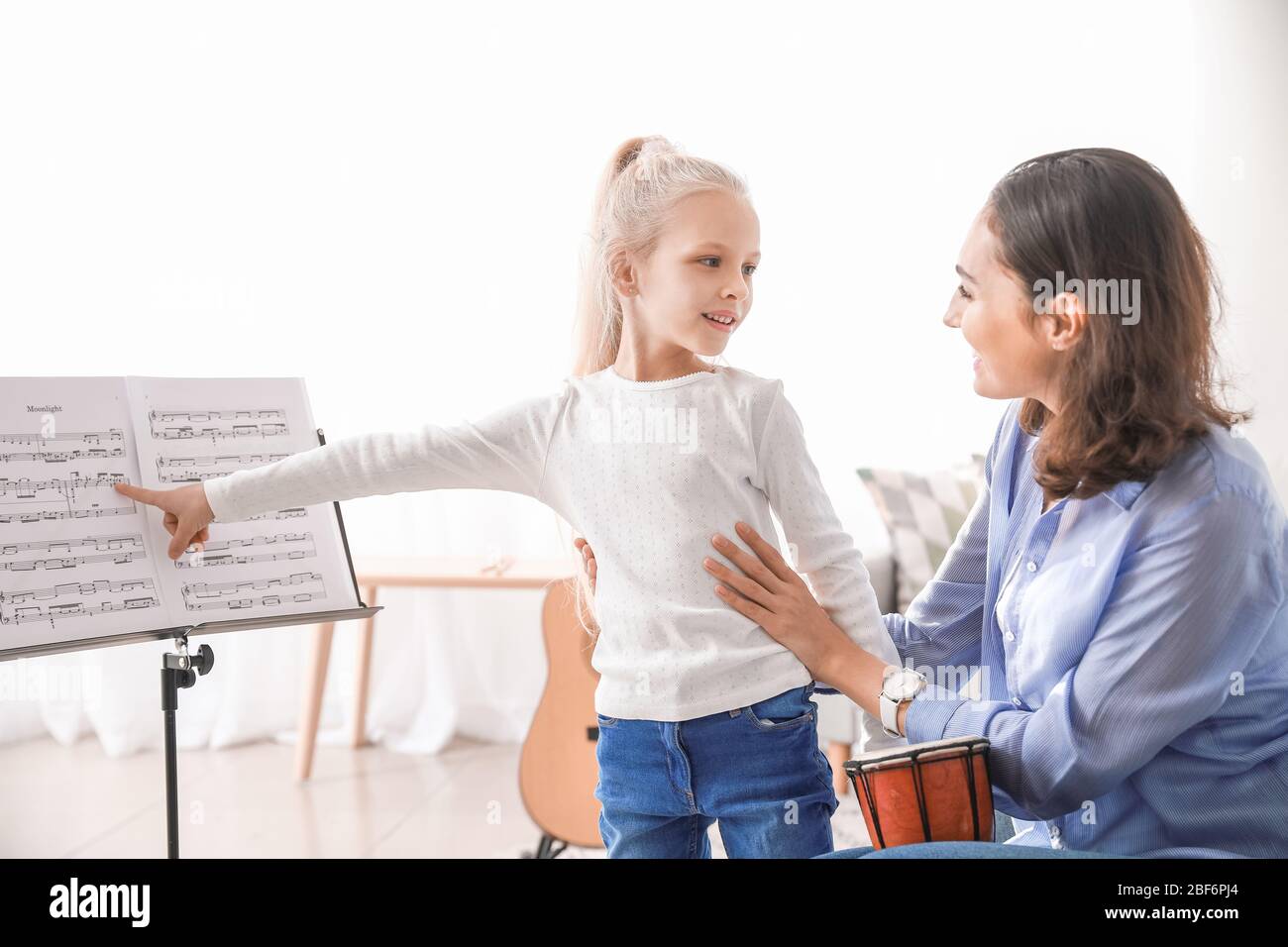 Private music teacher giving lessons to little girl at home Stock Photo ...