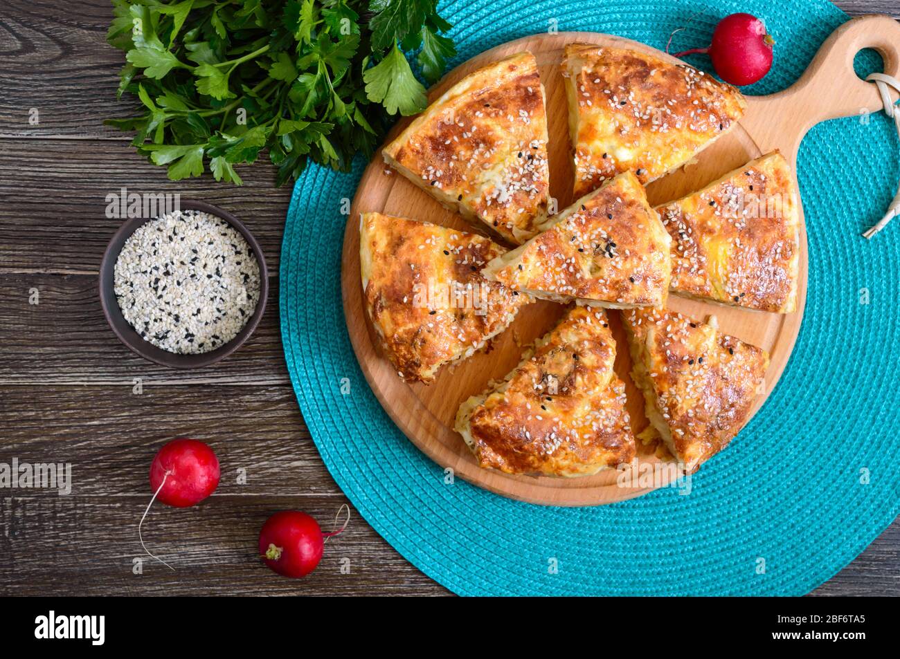 Burek Turkish pie. Lavash puff pie with cheese and sesame seeds. Top view. Stock Photo