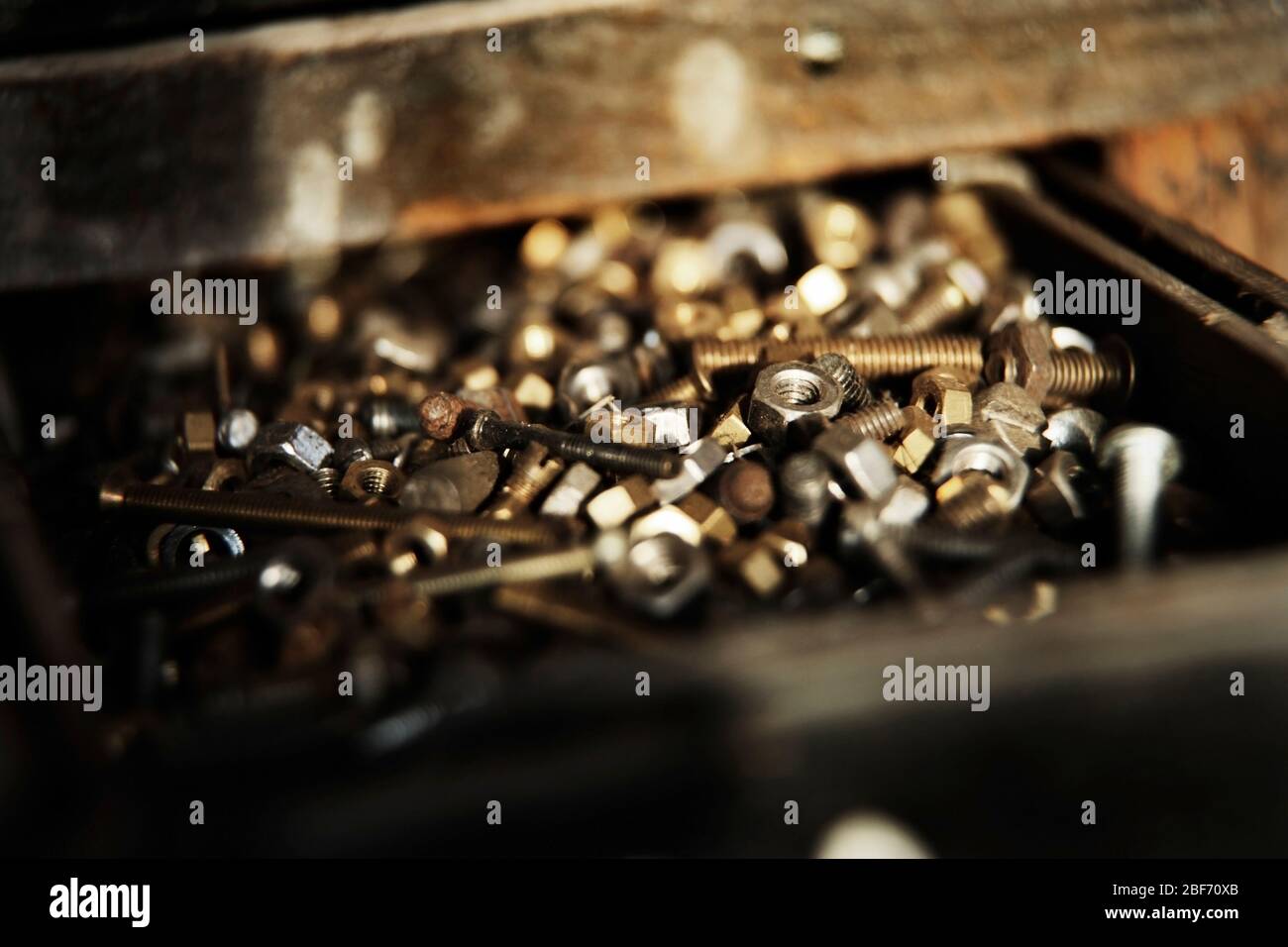 Small nuts and bolts in wooden drawer of old tool Stock Photo