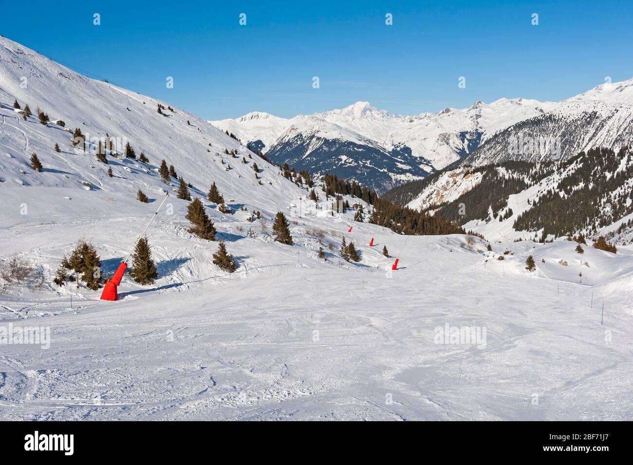 View down an alpine winter sport piste on mountain in ski resort Stock Photo