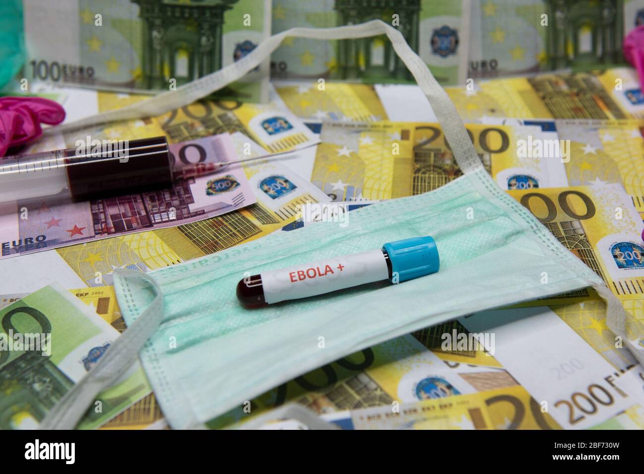 Euro money and tube with blood and positive test at Ebola. Stock Photo