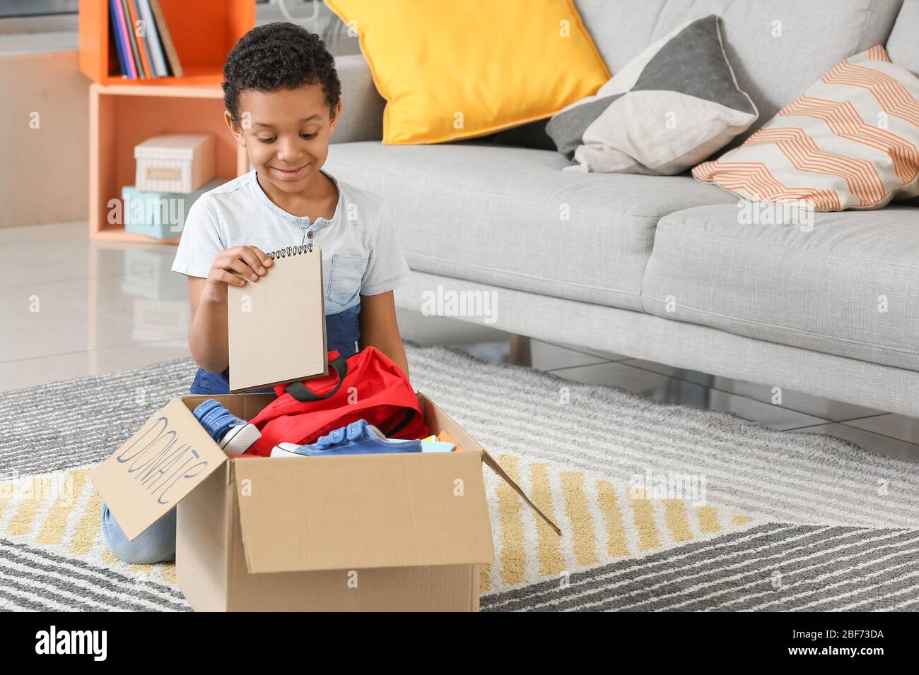 Little African-American boy with donations at orphan home Stock Photo