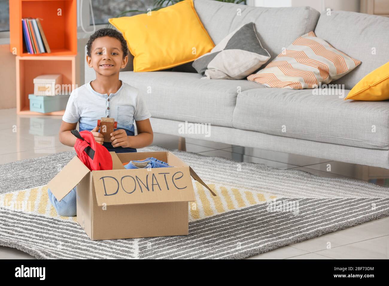 Little African-American boy with donations at orphan home Stock Photo