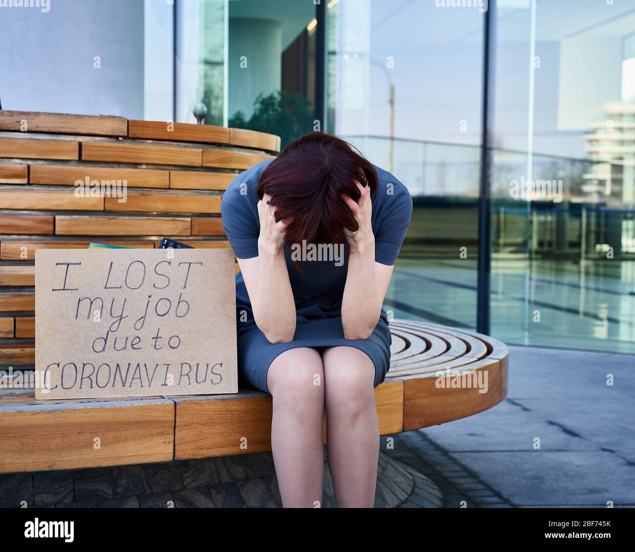 Woman holds sign saying "I lost my job because of coronavirus." Stock Photo
