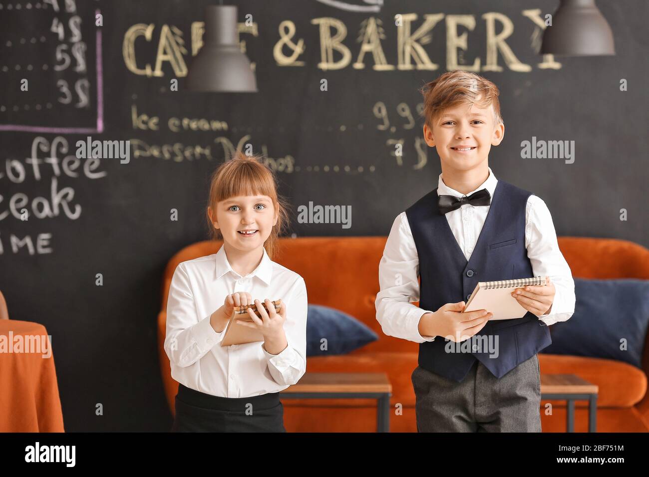 Cute little waiters in restaurant Stock Photo - Alamy