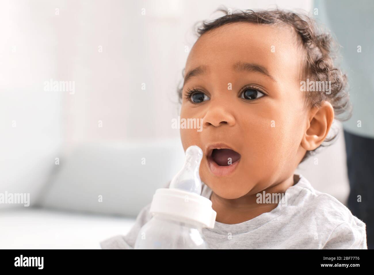 AfricanAmerican baby with bottle of water at home Stock Photo Alamy