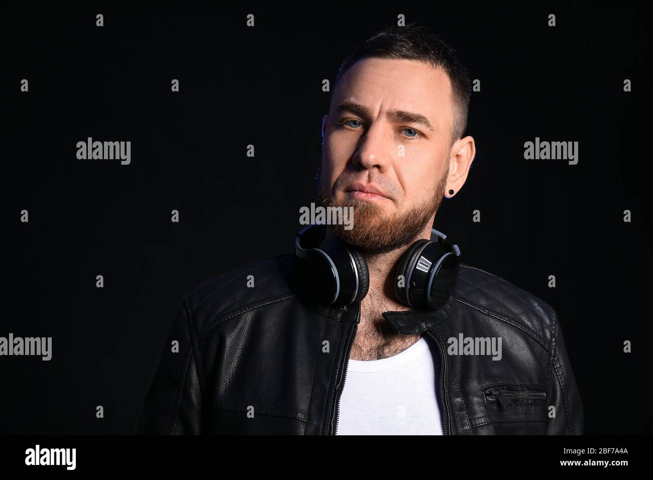 Handsome man with headphones on dark background Stock Photo