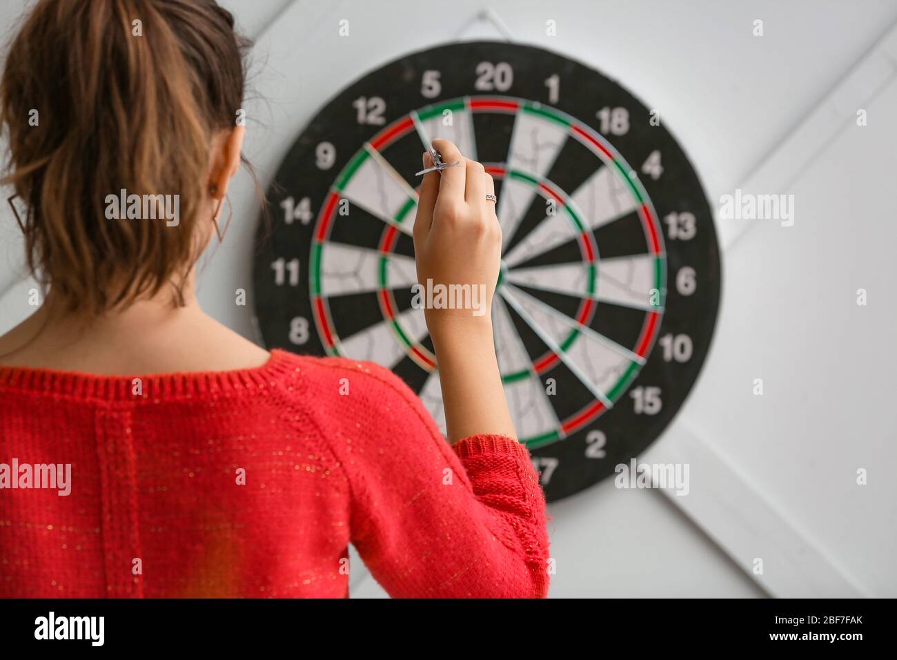 Young woman playing darts indoors Stock Photo Alamy