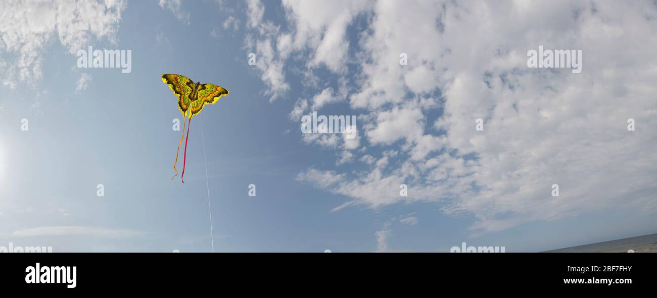 Wide-angle of blue sky and clouds with a flying kite Stock Photo