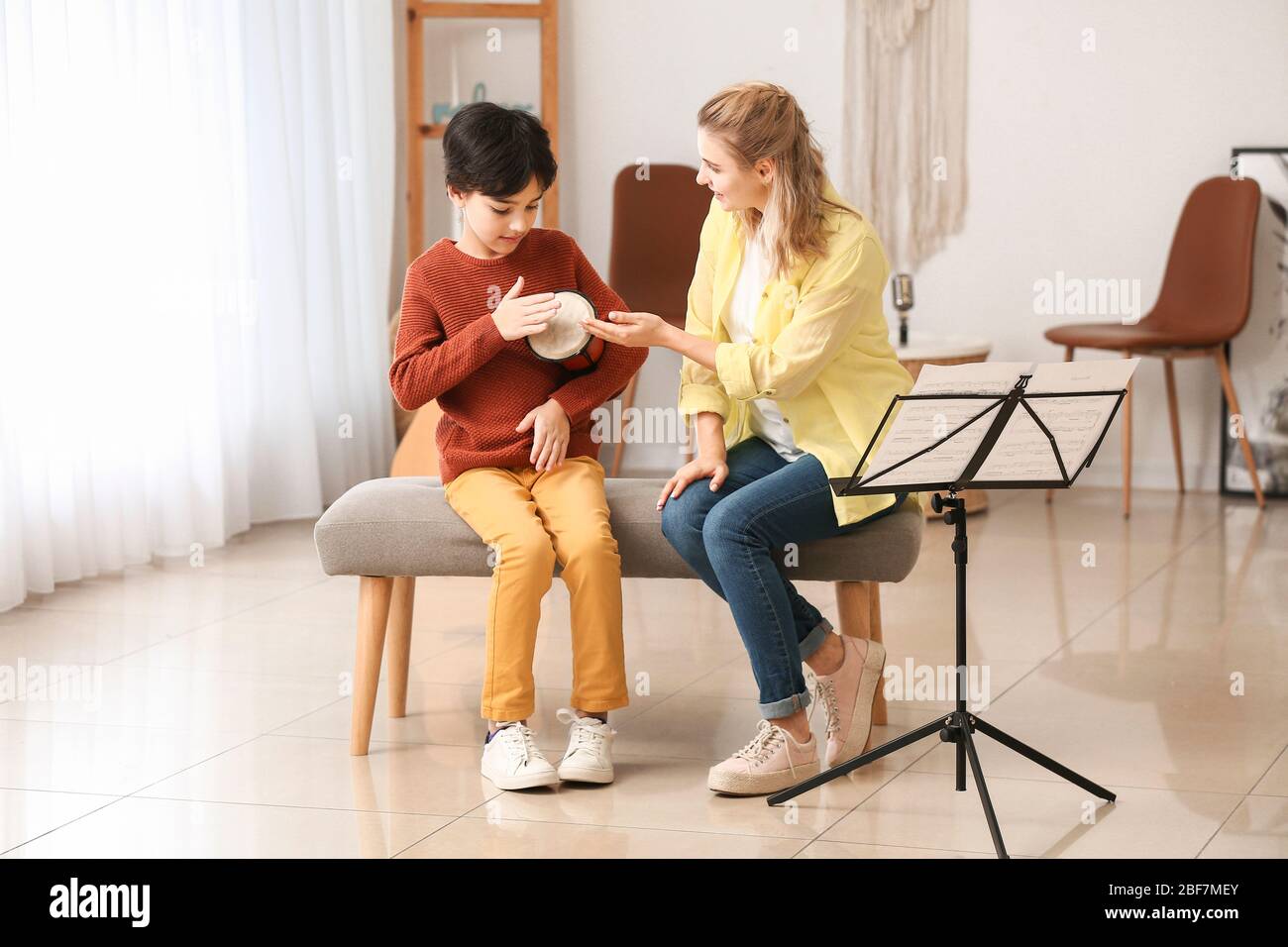 Private music teacher giving lessons to little boy at home Stock Photo ...