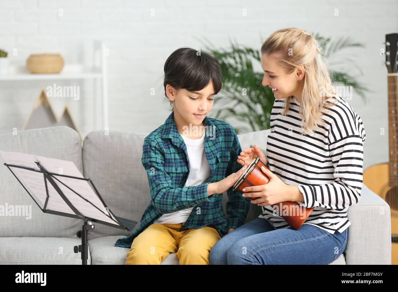 Private music teacher giving lessons to little boy at home Stock Photo ...