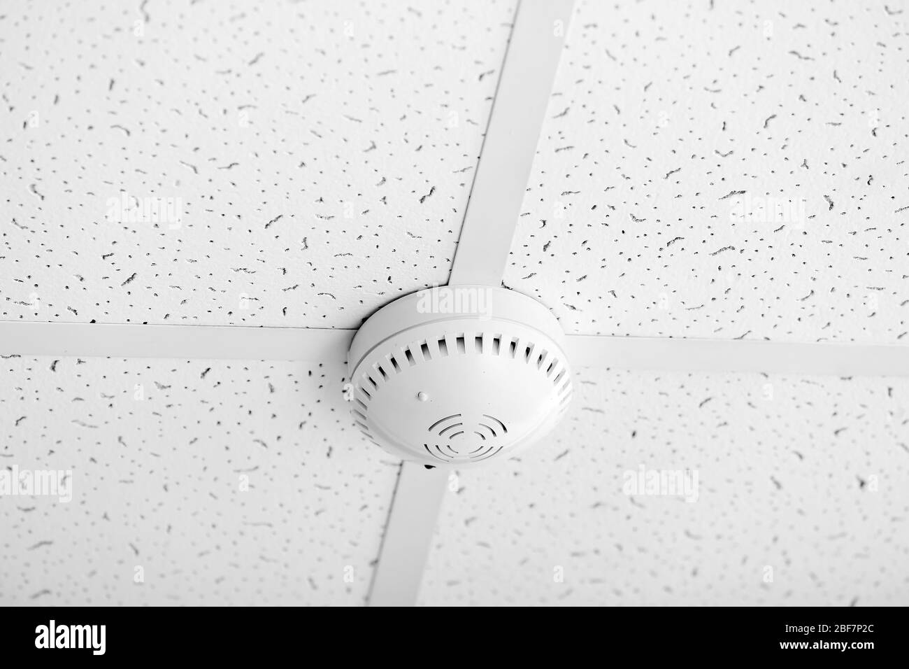 Modern smoke detector on ceiling Stock Photo