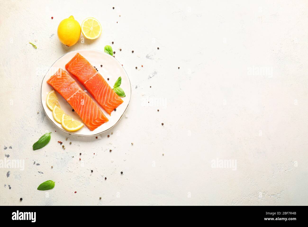 Raw salmon fillet with spices and lemon on white background Stock Photo ...