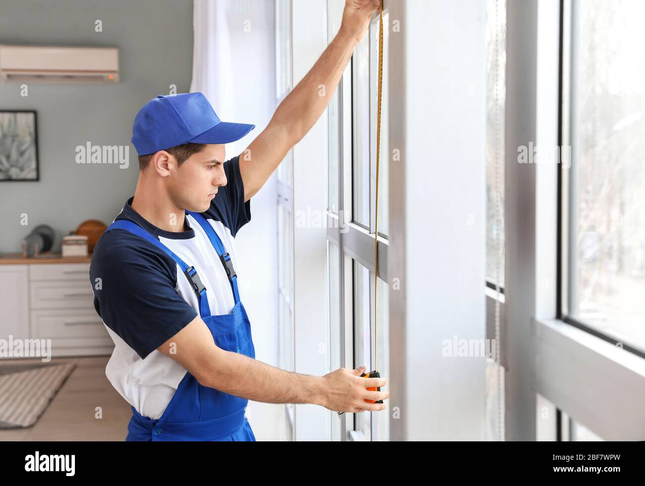 Male worker installing window in flat Stock Photo