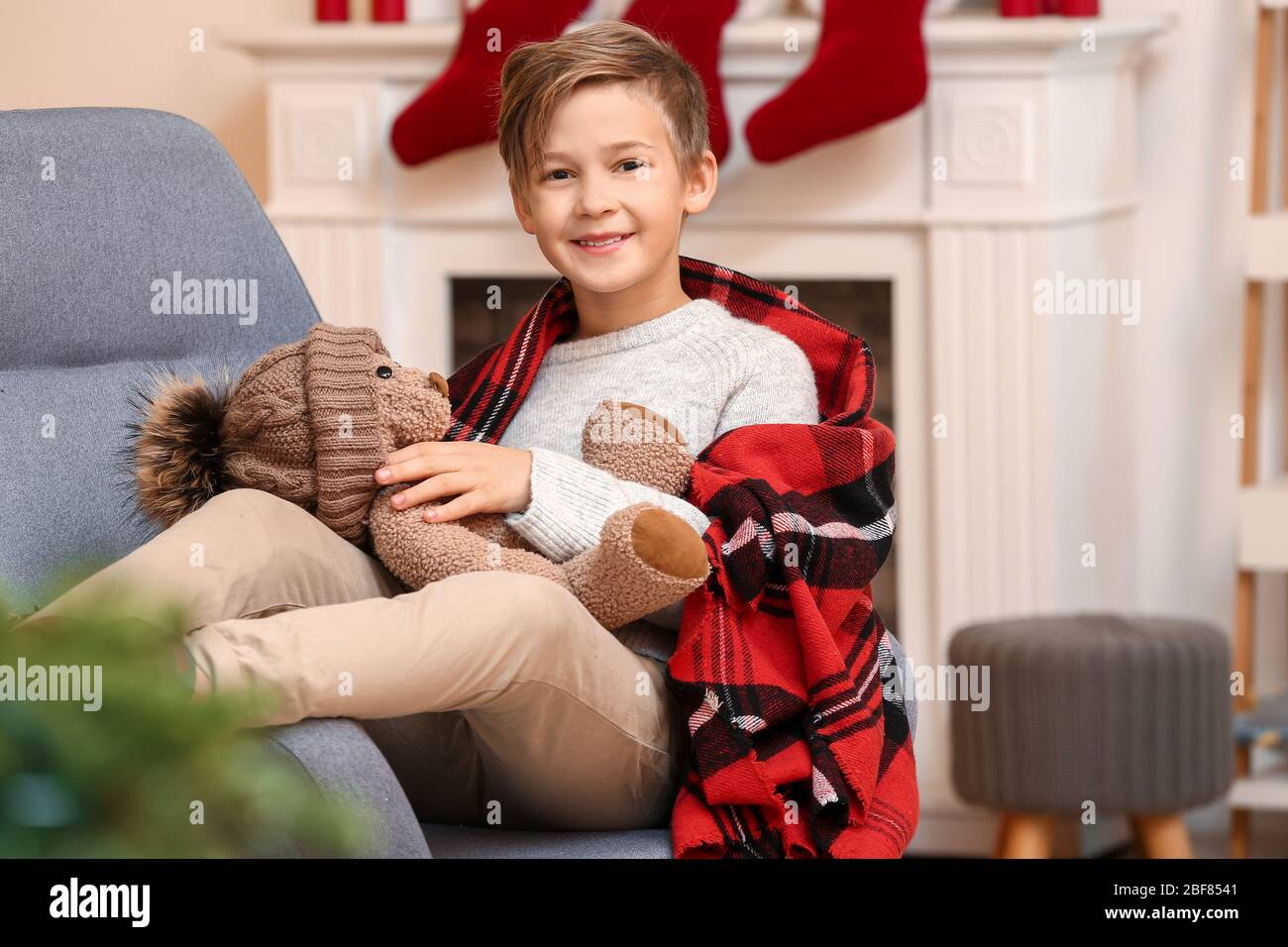 Cute little boy with teddy bear on Christmas eve at home Stock Photo ...