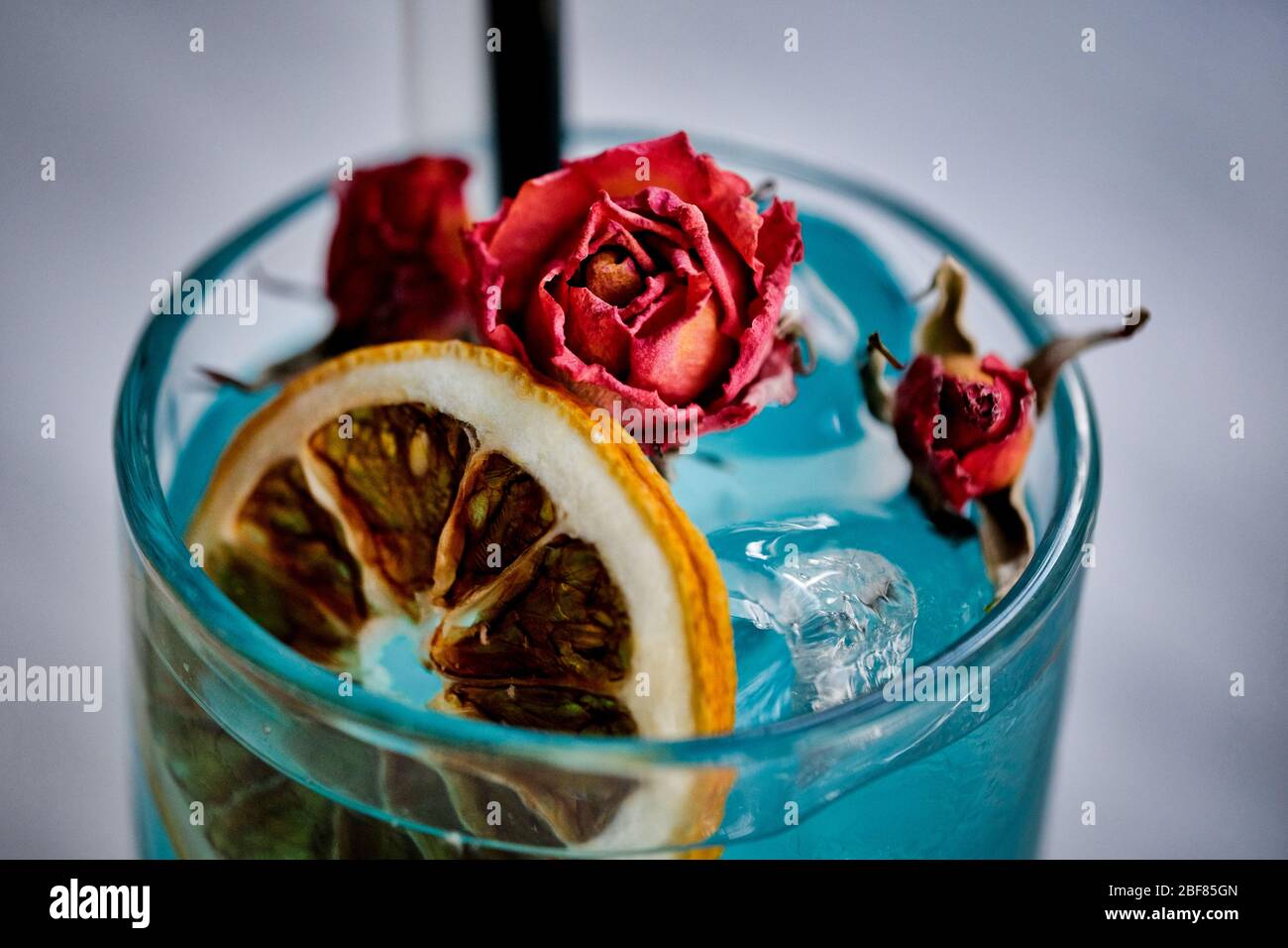 Blue Exotic alcoholic cocktails decorated with Lemon and Pink Rose on marble table. Soft drinks at the marble table. Stock Photo