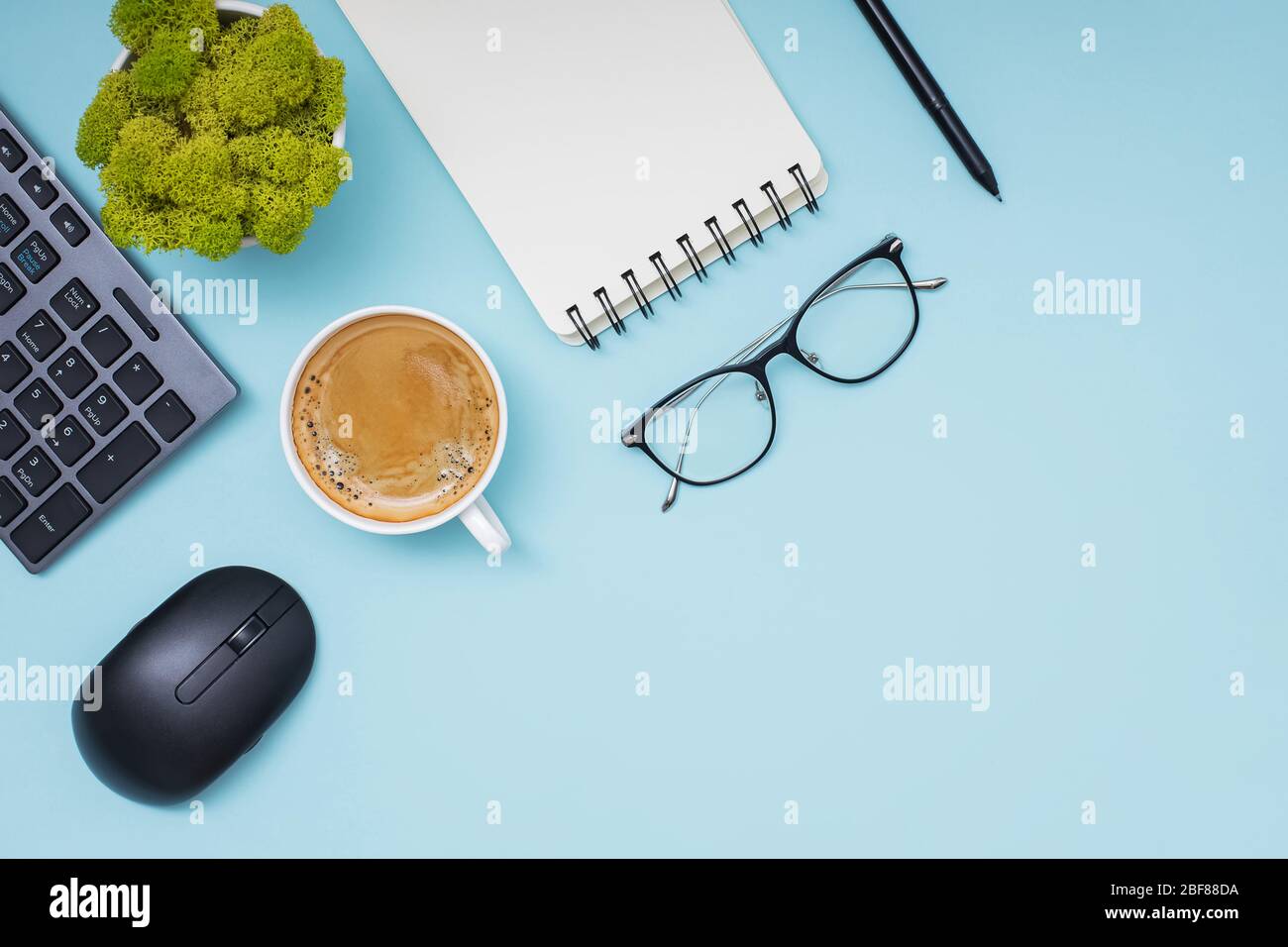 Flat lay with coffee, keyboard, empty paper notepad and other office related objects Stock Photo