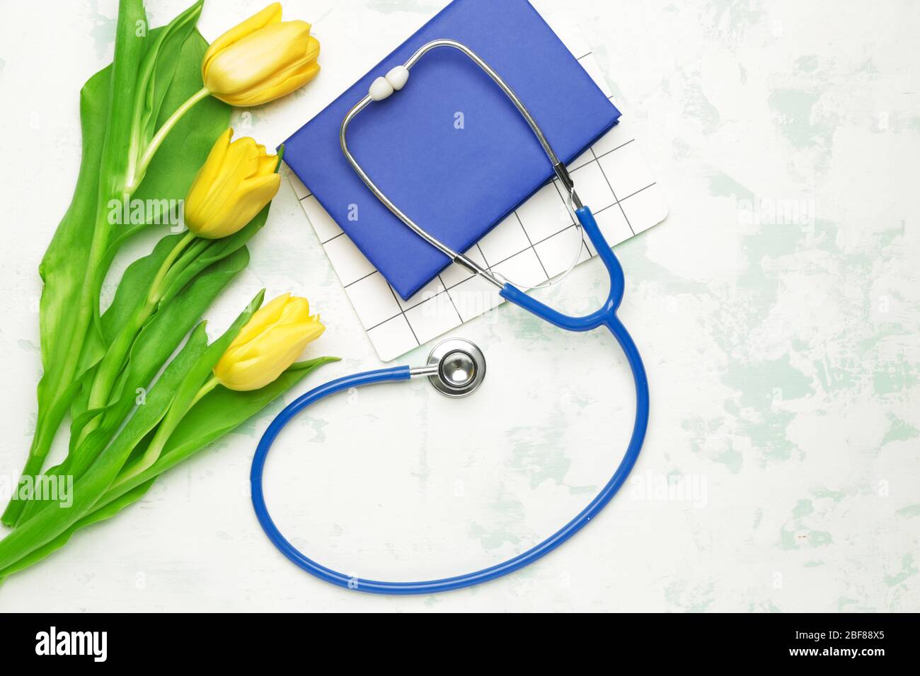 Stethoscope with flowers and notebooks on white background Stock Photo ...