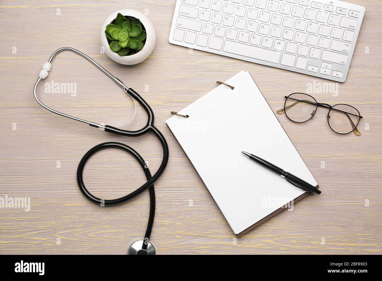 Stethoscope with computer keyboard and notebook on wooden table Stock ...