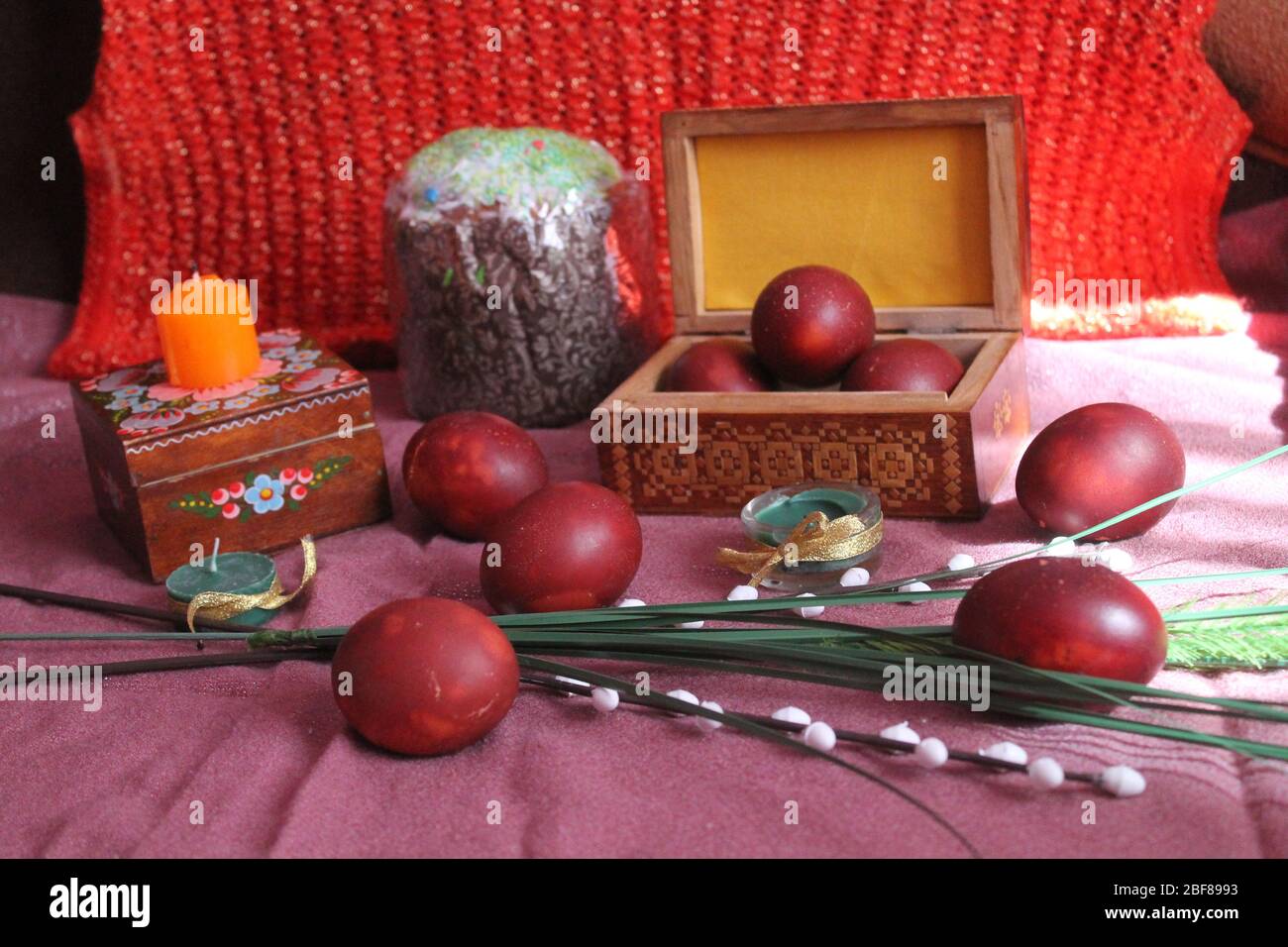 red painted eggs with flowers and candles for celebration Easter holiday Stock Photo