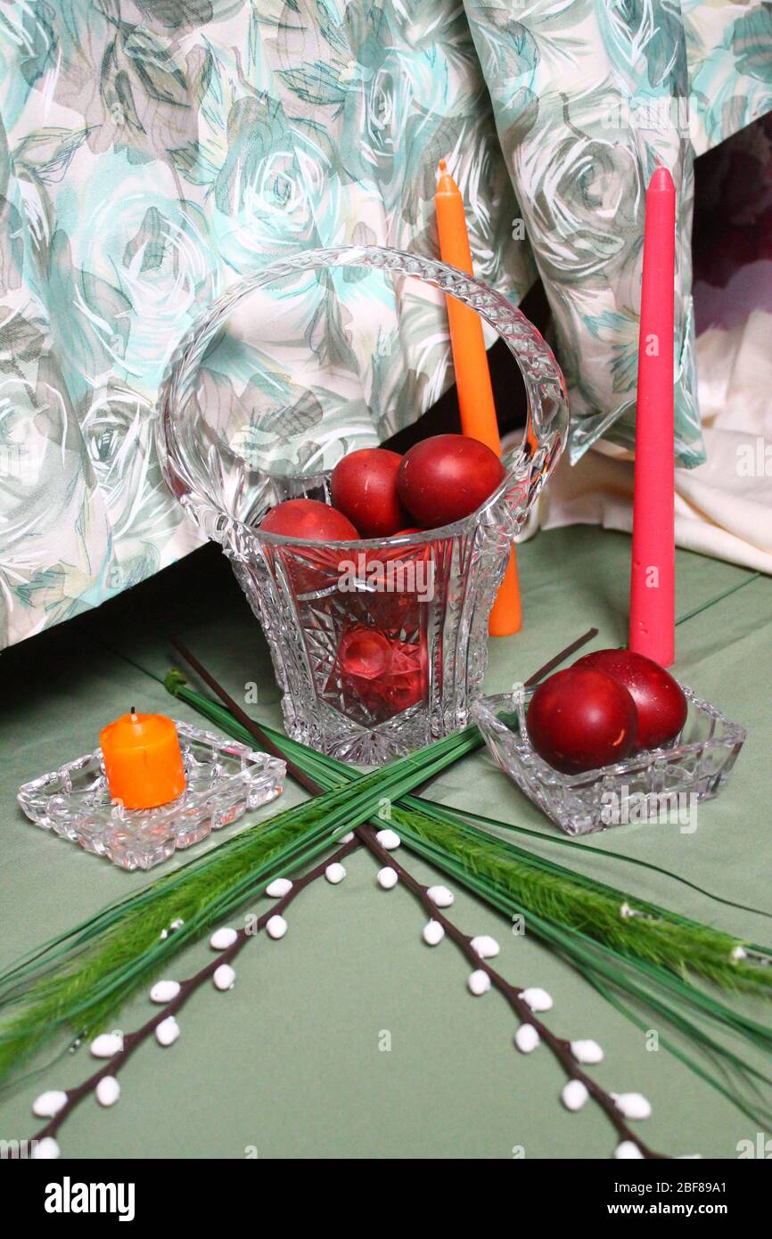 red painted eggs with flowers and candles for celebration Easter holiday Stock Photo
