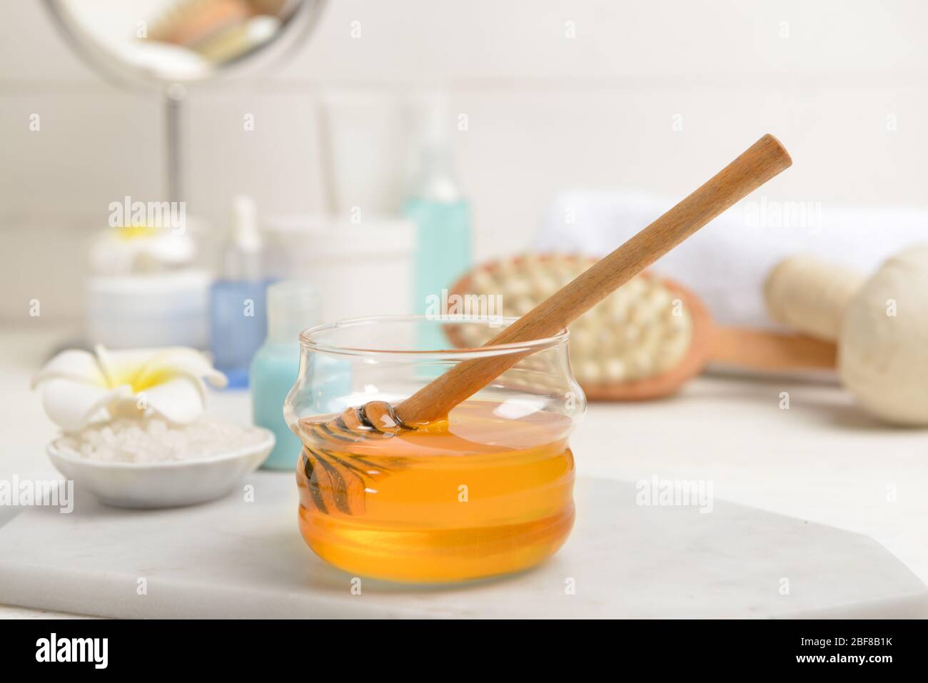 Jar with honey and spa items on table Stock Photo