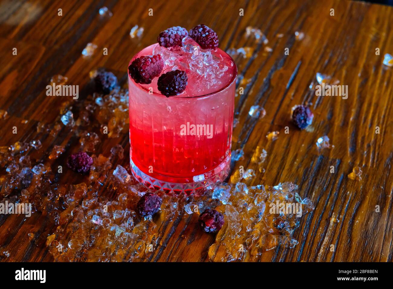 Red and Pink Fresh Colorful Exotic Alcoholic Cocktail with Blackberry on the Wooden Table. Red and Pink Mojito Stock Photo