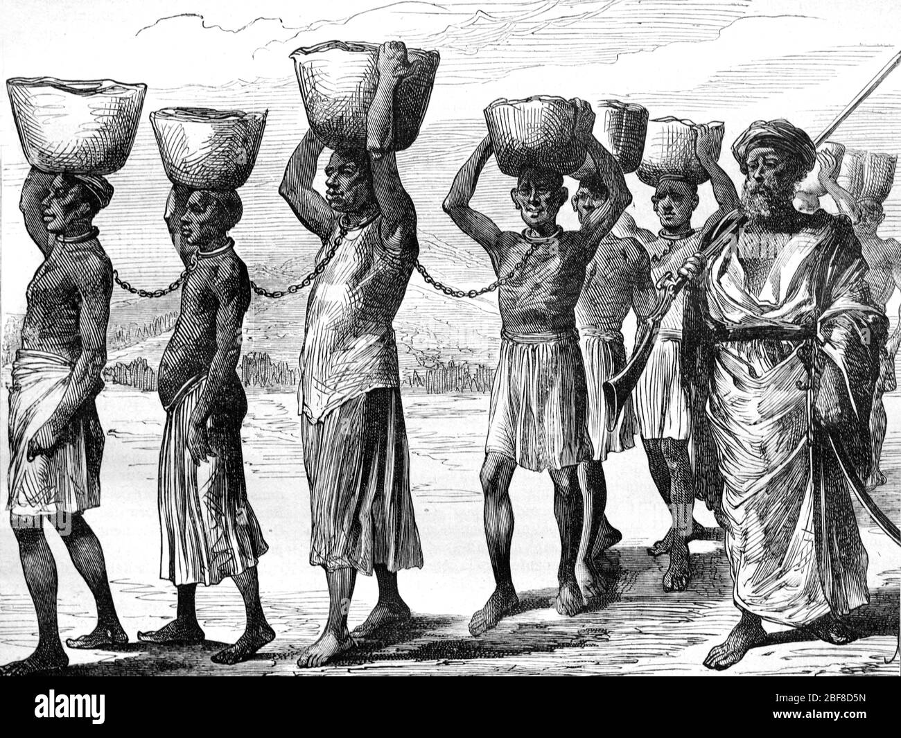 Arab Slave Trader Leading Chained African Slaves in Zanzibar Tanzania Africa. Vintage or Old Illustration or Engraving 1889 Stock Photo