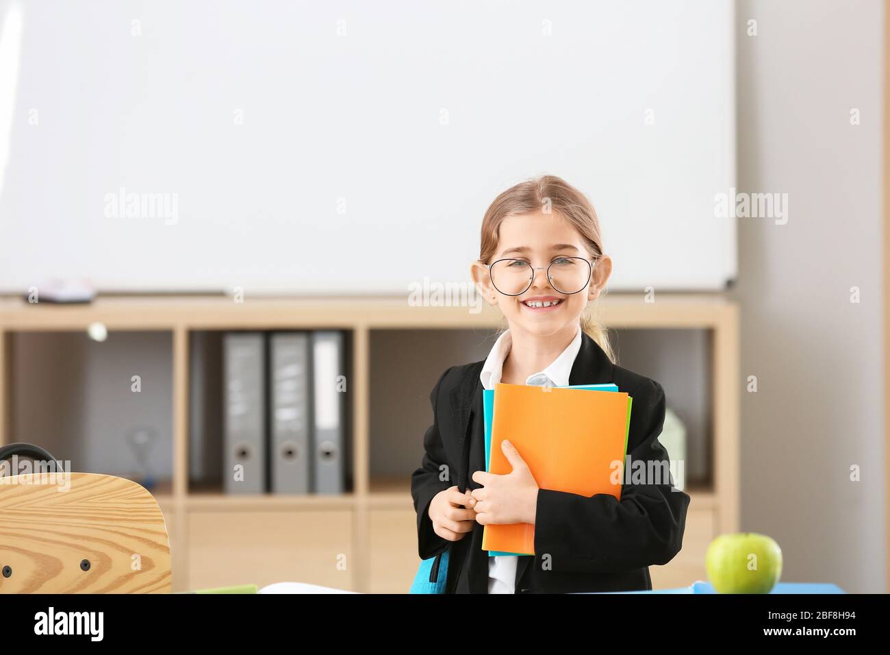 Cute little schoolgirl in classroom Stock Photo - Alamy