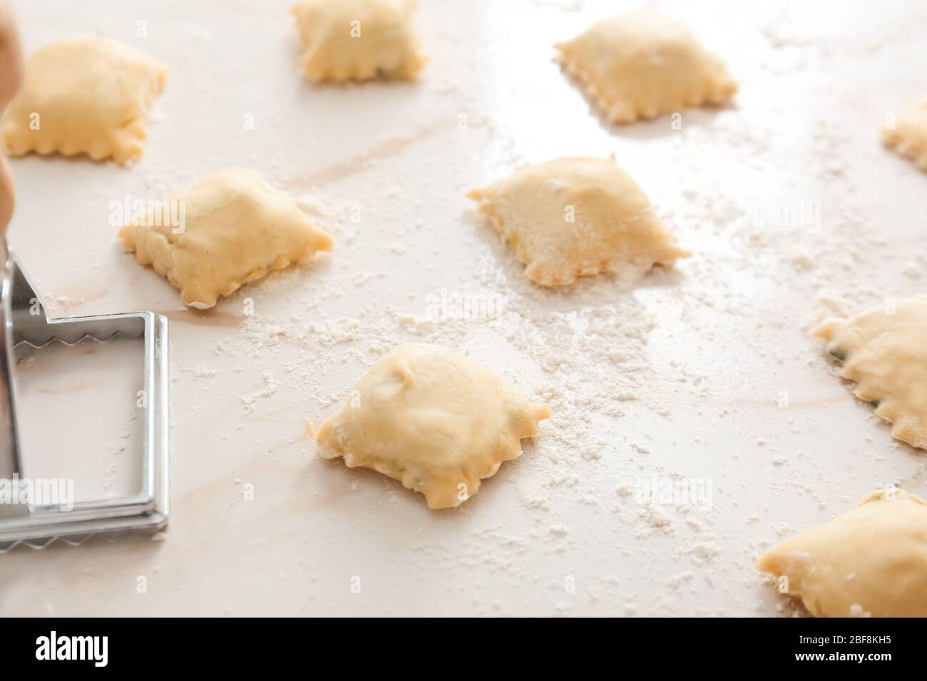 Raw ravioli with stamp on white background Stock Photo - Alamy
