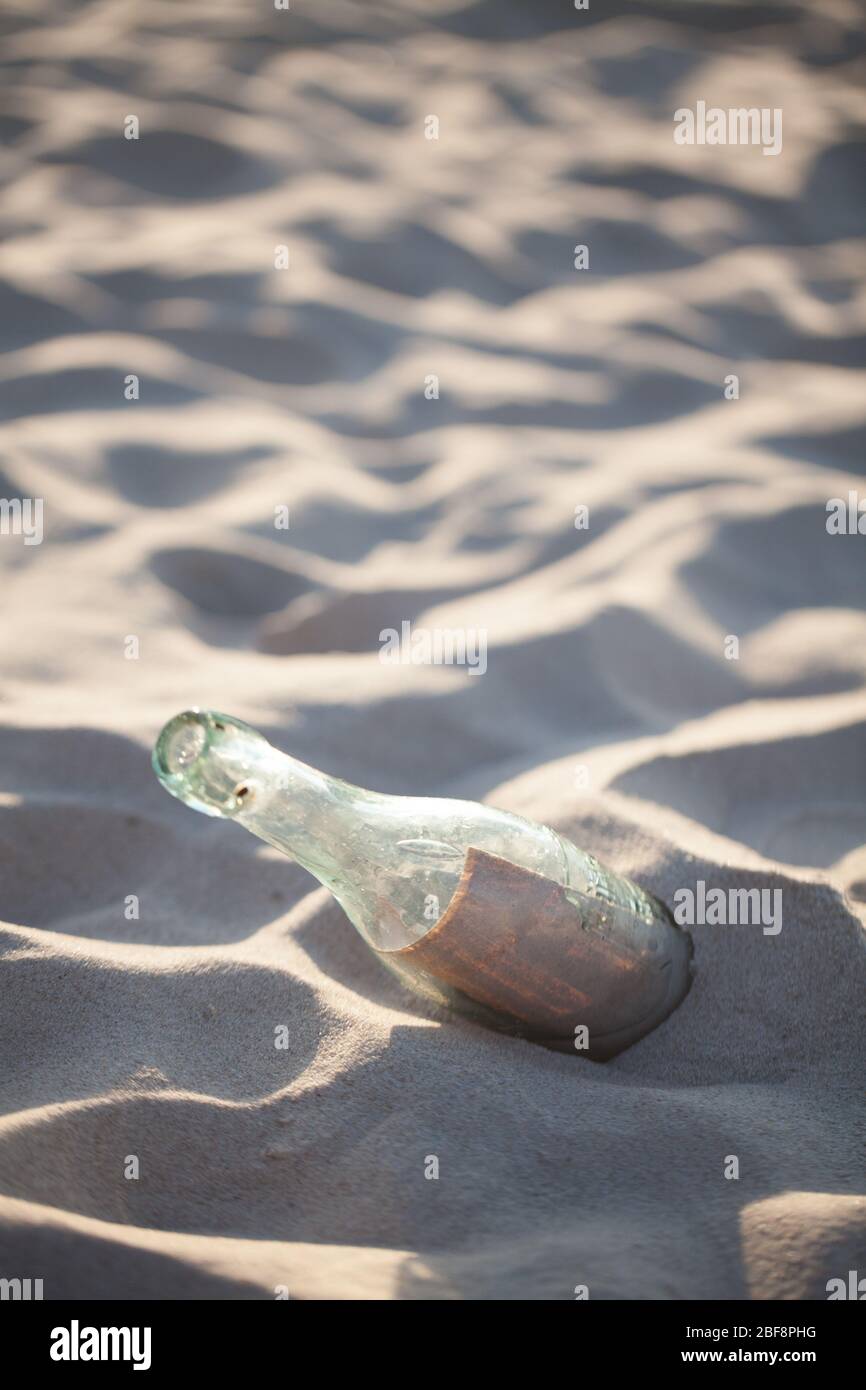 Letter in the bottle. A bottle with a letter buried on the beach Stock