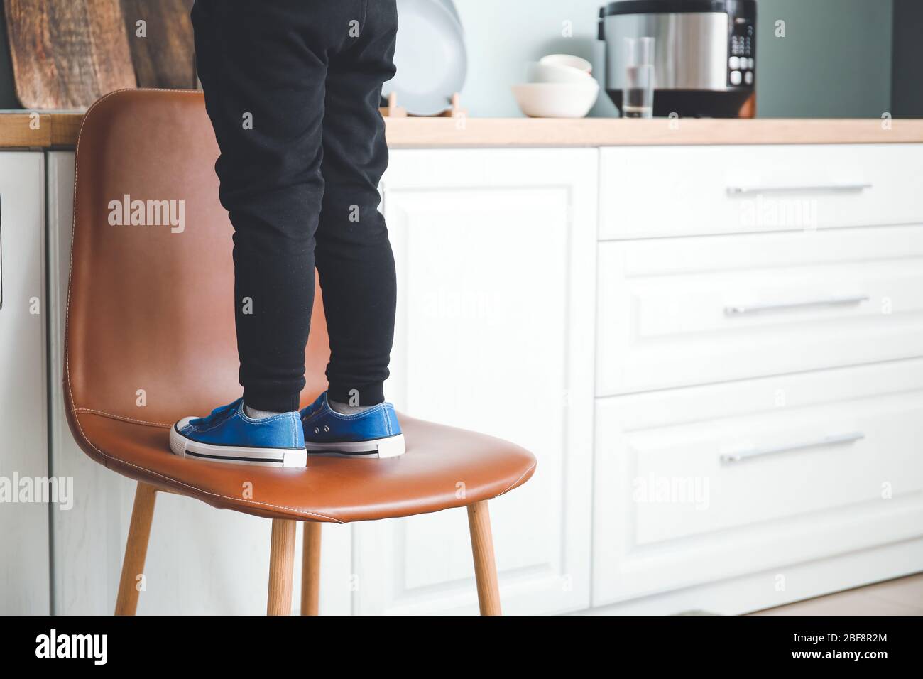 Little boy standing on chair at home Stock Photo