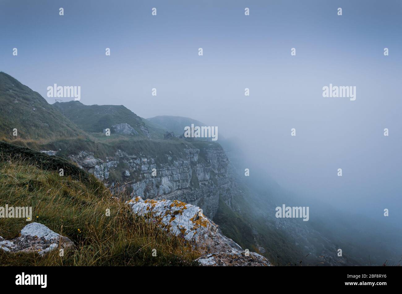 Cliff top view of the jurassic coast cliffs during foggy weather near