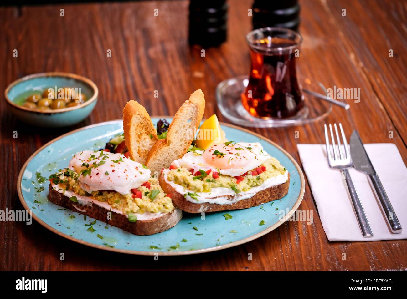 Traditional Turkish tea on bread for breakfast in the morning and Pois egg over avocado. Traditional Turkish tea and breakfast. Stock Photo