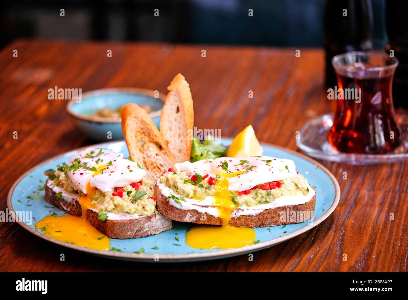 Traditional Turkish tea on bread for breakfast in the morning and Pois egg over avocado. Traditional Turkish tea and breakfast. Stock Photo